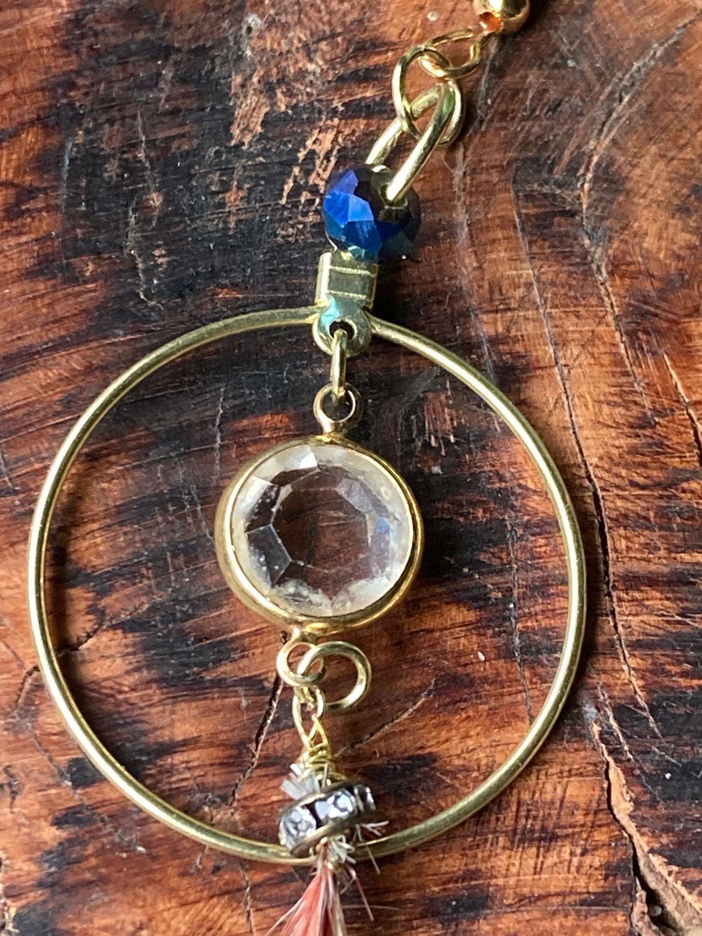 Gold circle crystal center with long dangling thin feathers, earrings