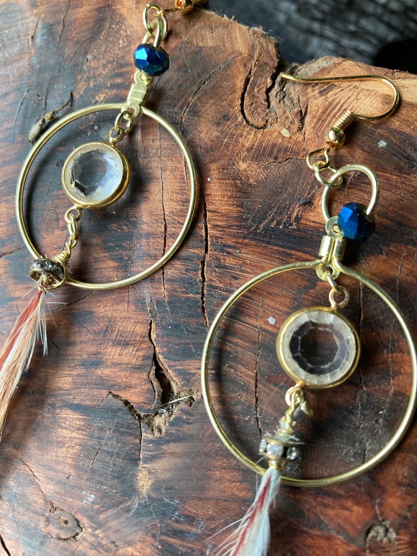 Gold circle crystal center with long dangling thin feathers, earrings